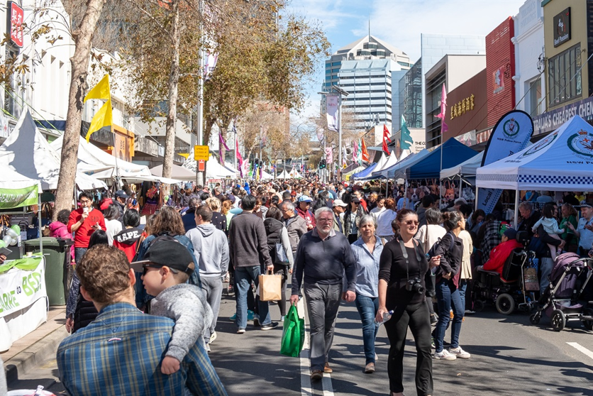 Victoria Avenue, Chatswood on market day — crowds, stalls and flags fill the street
